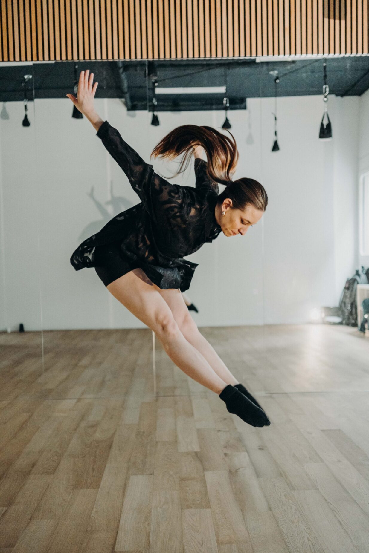 Danseuse en saut grand écart pendant un cours chez PoleMovement