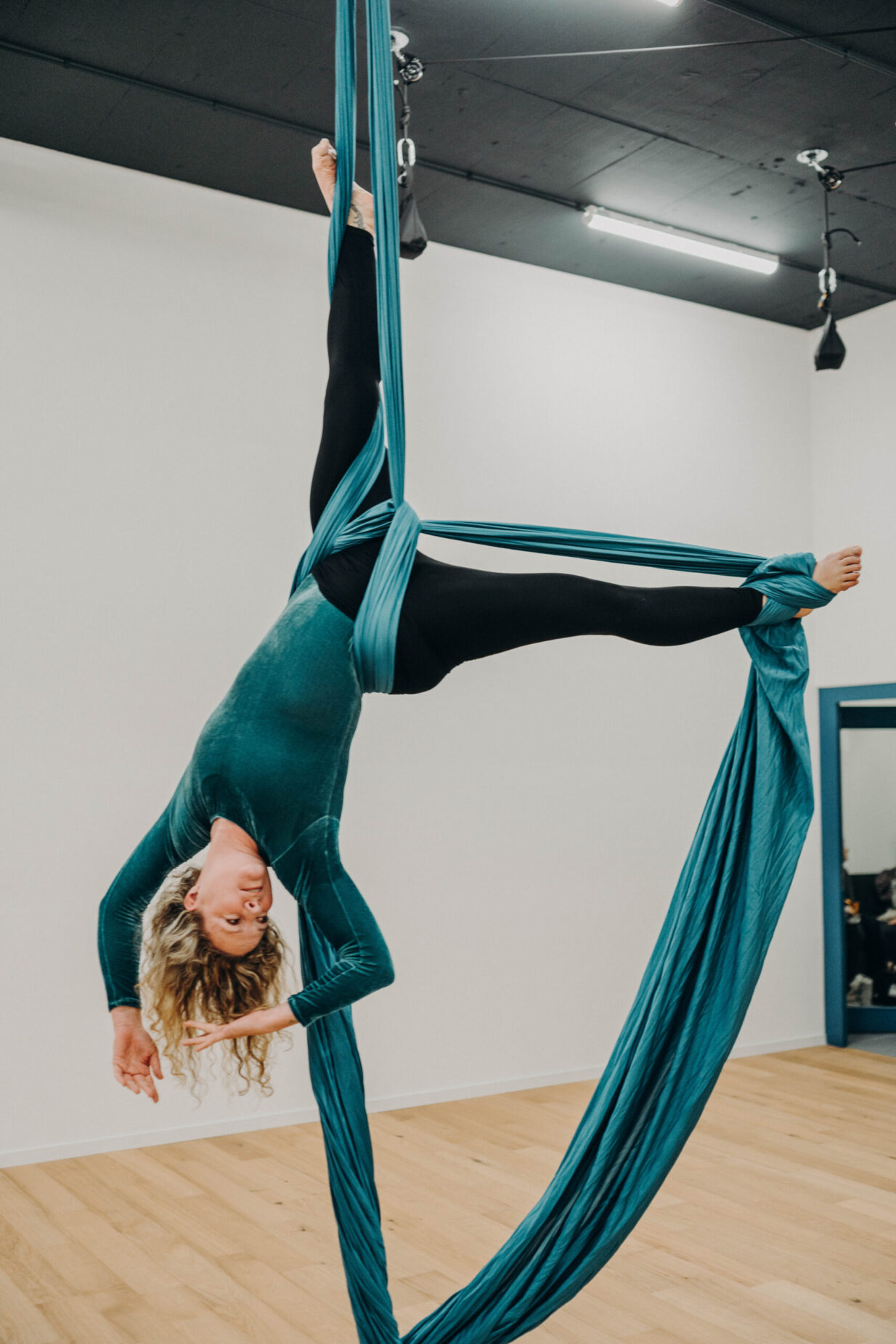 Élève en figure suspendue aux tissus aériens chez PoleMovement